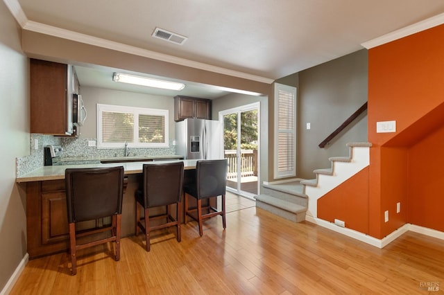 171 Nautical Ct, Vallejo, CA 94574 - kitchen featuring appliances with stainless steel finishes, light countertops, a peninsula, light wood-type flooring, and decorative backsplash