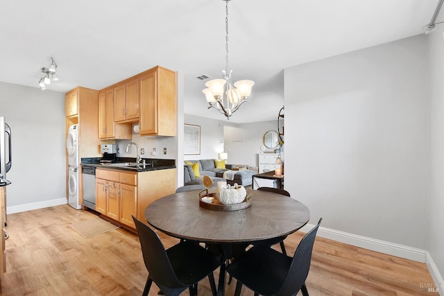 900 Cambridge Dr Unit 77, Benicia, CA 94510 - dining area with stacked washing machine and dryer, a chandelier, and light wood-style floors
