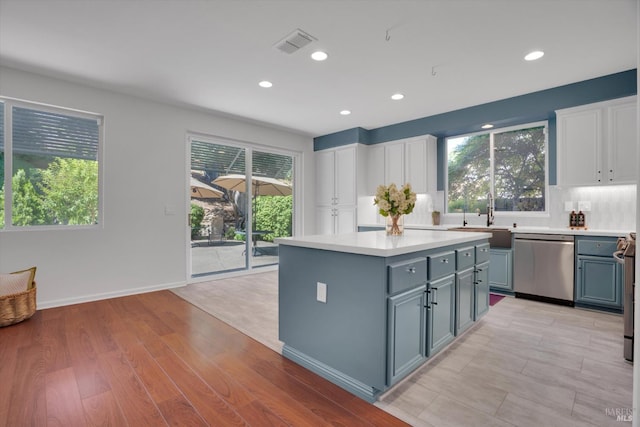 494 Mccall Dr, Benicia, CA 94510 - kitchen with stainless steel dishwasher, white cabinetry, light countertops, healthy amount of natural light, and recessed lighting