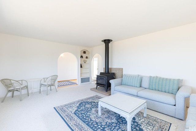 359 Terra Verde, Bodega Bay, CA 94923 - living area with a wood stove, built in shelves, carpet flooring, and arched walkways