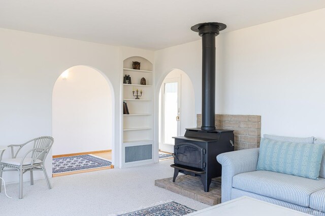 359 Terra Verde, Bodega Bay, CA 94923 - carpeted living room with a wood stove, built in shelves, and arched walkways