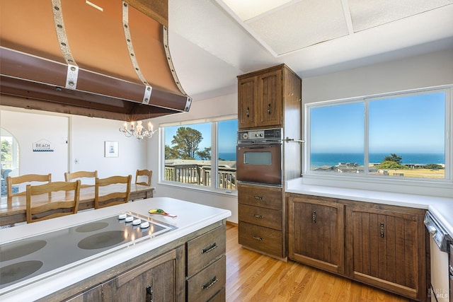 359 Terra Verde, Bodega Bay, CA 94923 - kitchen featuring oven, cooktop, ventilation hood, light wood-type flooring, and light countertops