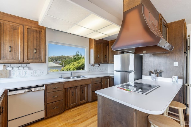 359 Terra Verde, Bodega Bay, CA 94923 - kitchen with white dishwasher, island exhaust hood, freestanding refrigerator, electric cooktop, and light wood-style flooring