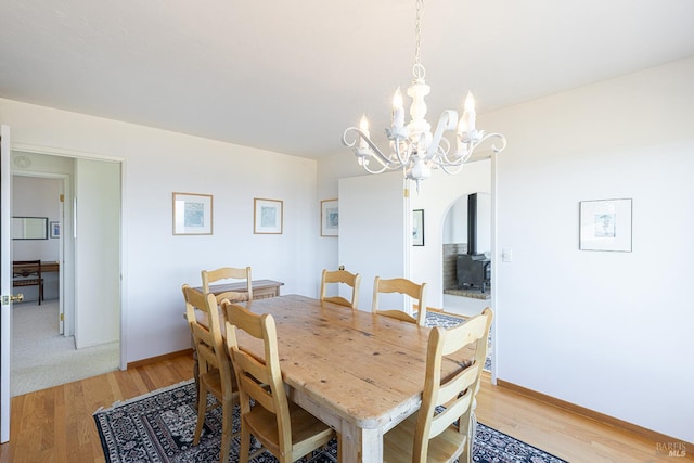 359 Terra Verde, Bodega Bay, CA 94923 - dining space with a chandelier, light wood-type flooring, arched walkways, and a wood stove
