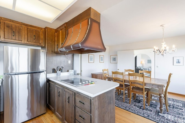 359 Terra Verde, Bodega Bay, CA 94923 - kitchen with freestanding refrigerator, electric stovetop, premium range hood, light wood-style flooring, and a peninsula
