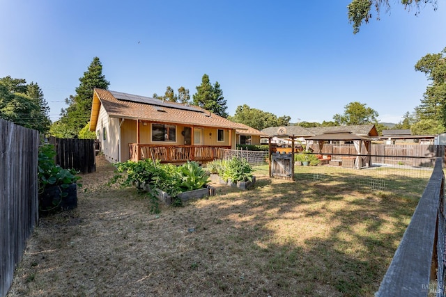 1851 Daniel Way, Redwood Valley, CA 95470 - rear view of house with roof mounted solar panels, a garden, and a fenced backyard