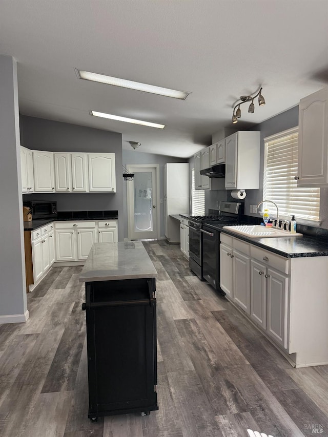 1803 New Long Valley Rd, Clearlake Oaks, CA 95423 - kitchen with gas stove, under cabinet range hood, dark wood finished floors, a kitchen island, and white cabinets