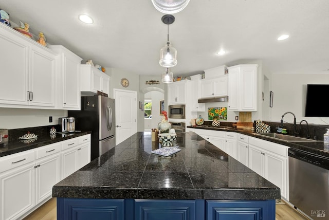 644 Canterbury Cir, Vacaville, CA 95687 - kitchen featuring appliances with stainless steel finishes, a kitchen island, arched walkways, white cabinets, and recessed lighting