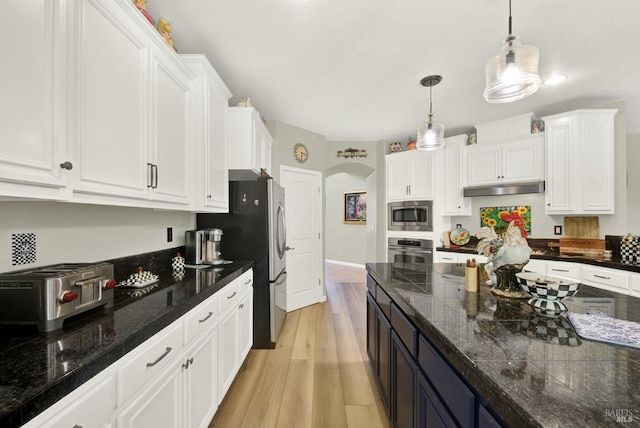 644 Canterbury Cir, Vacaville, CA 95687 - kitchen with appliances with stainless steel finishes, white cabinets, decorative light fixtures, arched walkways, and under cabinet range hood