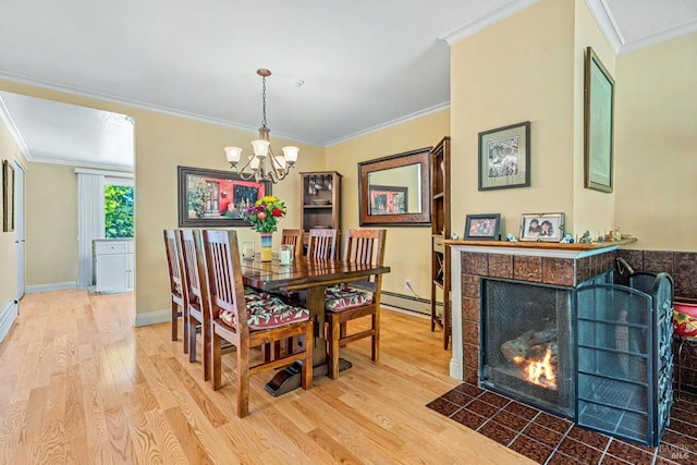 7771 Healdsburg Ave Unit 22, Sebastopol, CA 95472 - dining area featuring wood finished floors, crown molding, a chandelier, a tiled fireplace, and a baseboard radiator