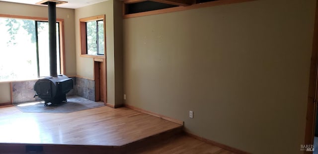 24663 Clover Rd, Willits, CA 95490 - unfurnished room featuring a wood stove and wood finished floors