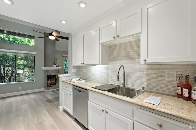 4 Cielo Ln Unit 3E, Novato, CA 94949 - kitchen with stainless steel dishwasher, a ceiling fan, white cabinetry, a lit fireplace, and tasteful backsplash