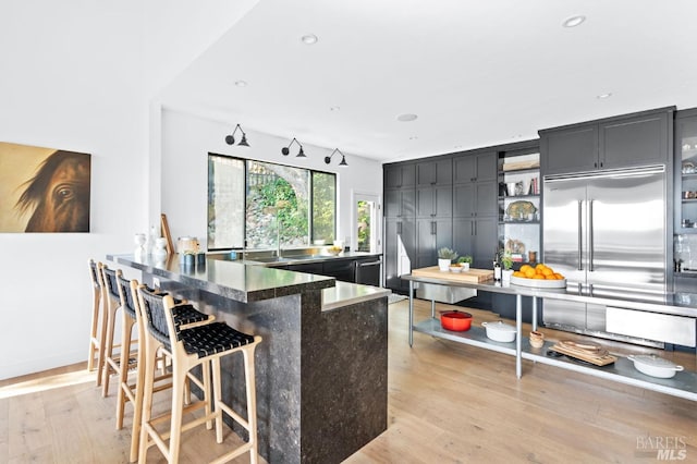 1325 Crestmont Dr, Angwin, CA 94508 - kitchen featuring light wood-style flooring, a peninsula, a kitchen breakfast bar, open shelves, and stainless steel built in fridge