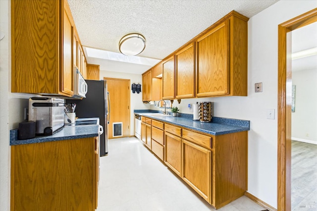 2393 Ohio St, Eureka, CA 95501 - kitchen with dark countertops, brown cabinets, appliances with stainless steel finishes, and a textured ceiling