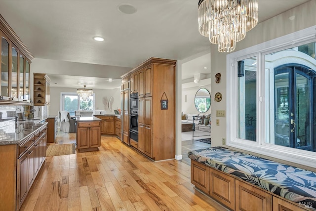 18903 N Shore Dr, Hidden Valley Lake, CA 95467 - kitchen featuring a chandelier, light wood-type flooring, brown cabinetry, glass insert cabinets, and a warming drawer