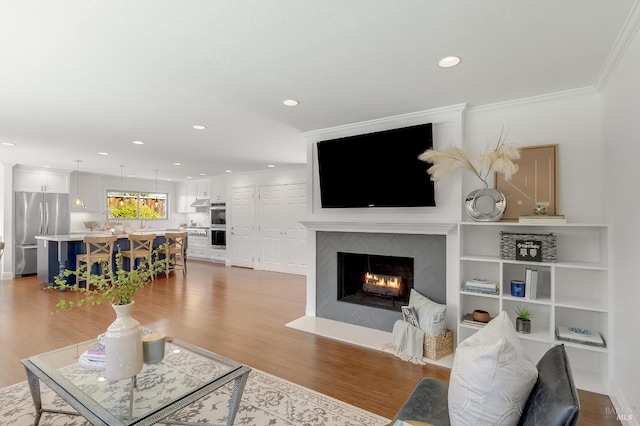 251 Donegal Way, Martinez, CA 94553 - living room featuring wood finished floors, recessed lighting, a warm lit fireplace, and crown molding