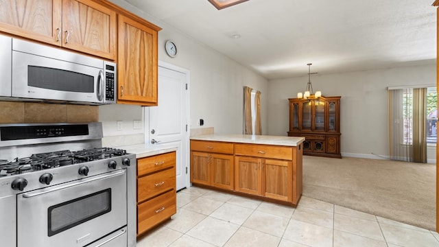 2077 Bourbon St, Pollock Pines, CA 95726 - kitchen featuring stainless steel appliances, light countertops, light carpet, a peninsula, and brown cabinetry