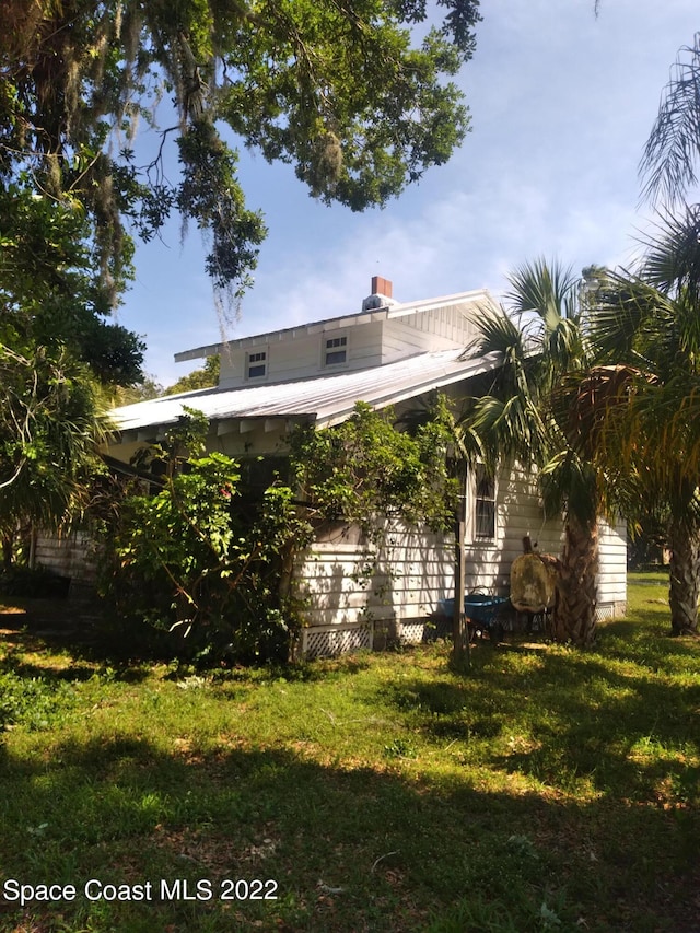 rear view of property featuring a lawn