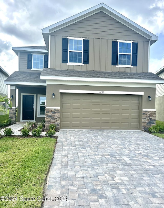 view of front of property featuring a garage and a front lawn