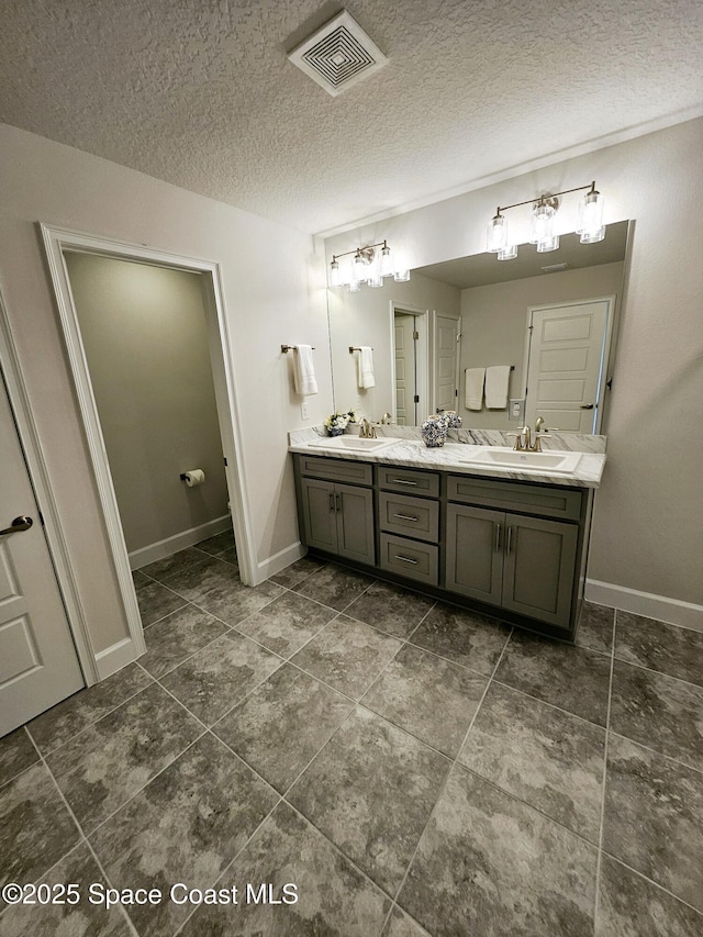 bathroom with a textured ceiling and vanity