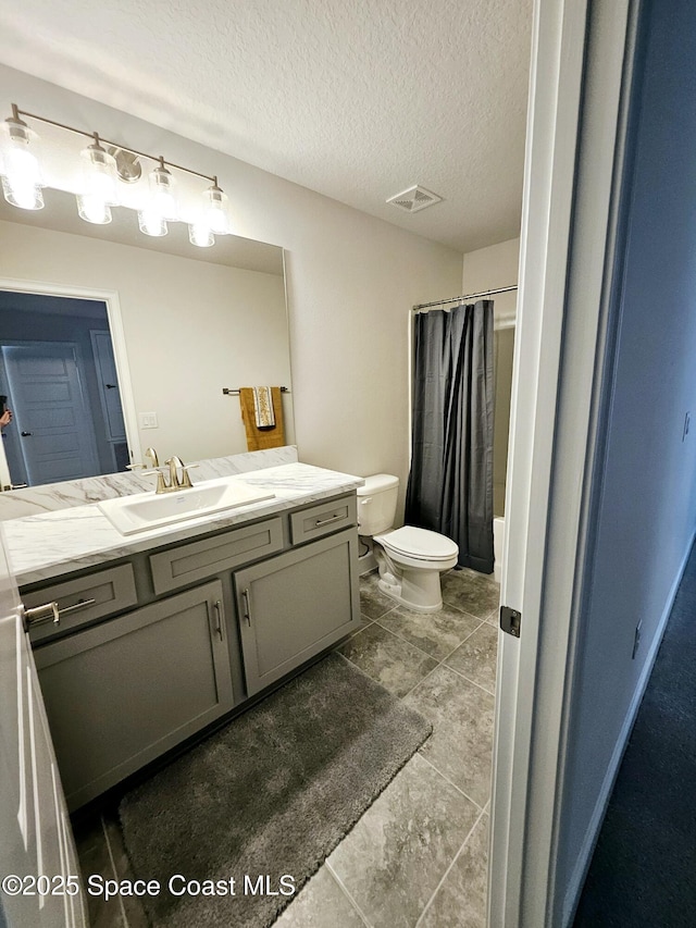 full bathroom featuring vanity, shower / tub combo, toilet, and a textured ceiling