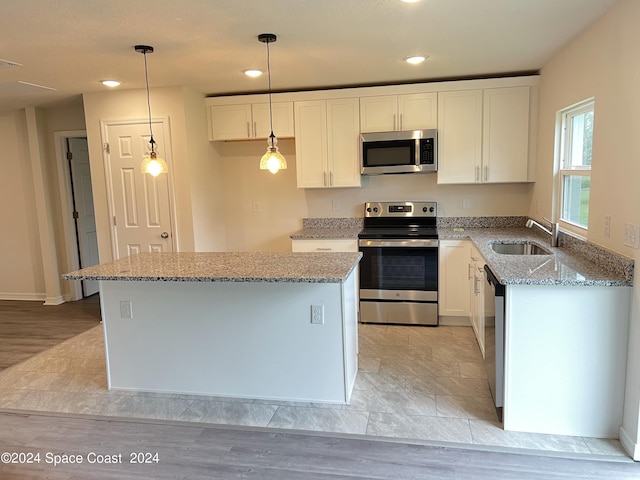 kitchen featuring light hardwood / wood-style floors, appliances with stainless steel finishes, sink, and white cabinets