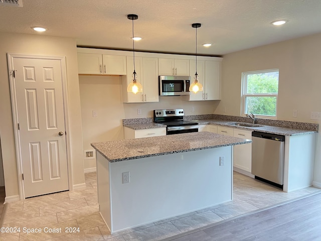 kitchen with white cabinets, a center island, and appliances with stainless steel finishes