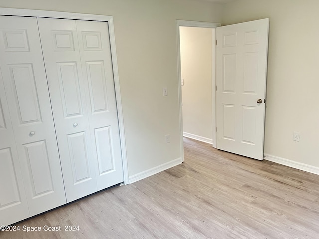 unfurnished bedroom featuring a closet and light hardwood / wood-style floors