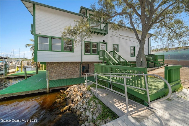 view of front of property with a water view and a dock