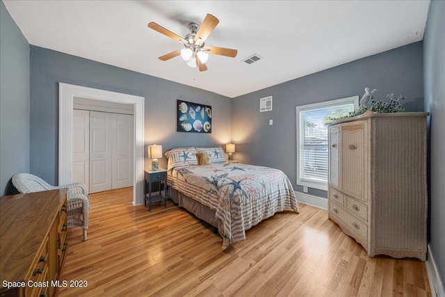 bedroom with ceiling fan, light hardwood / wood-style floors, and a closet