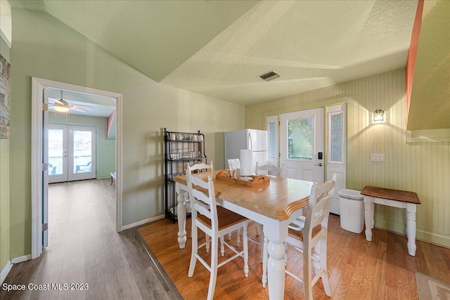 dining room featuring ceiling fan, light hardwood / wood-style flooring, french doors, and plenty of natural light