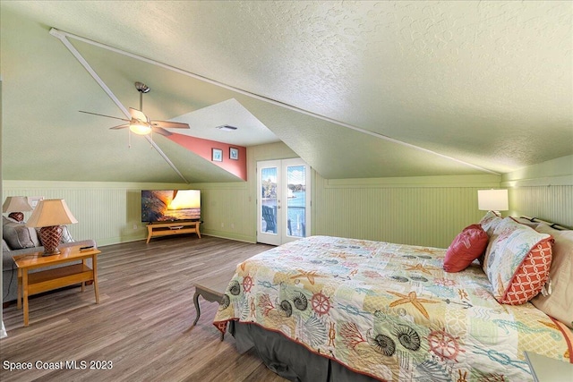 bedroom with ceiling fan, hardwood / wood-style floors, and vaulted ceiling