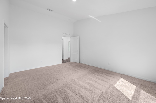 carpeted spare room featuring a high ceiling