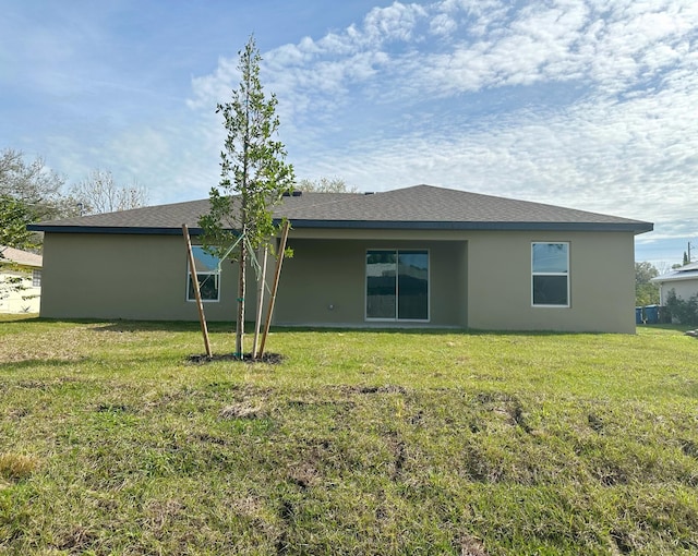 back of house featuring a lawn