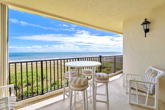 balcony featuring a water view and a view of the beach