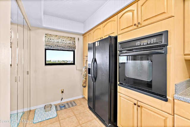 kitchen with light tile floors, black appliances, and light brown cabinetry