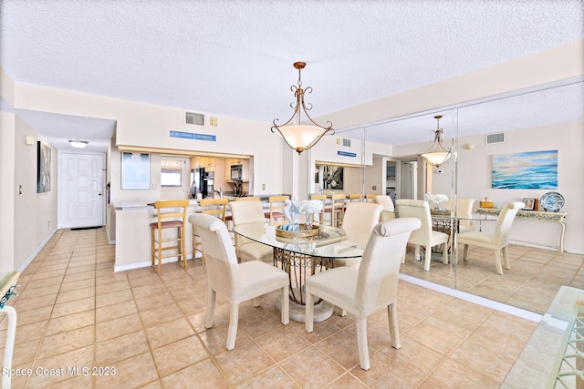 tiled dining area with a textured ceiling