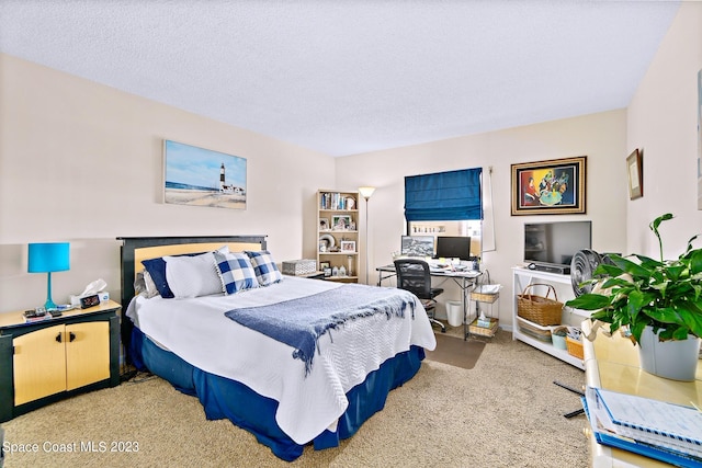 bedroom with light colored carpet and a textured ceiling