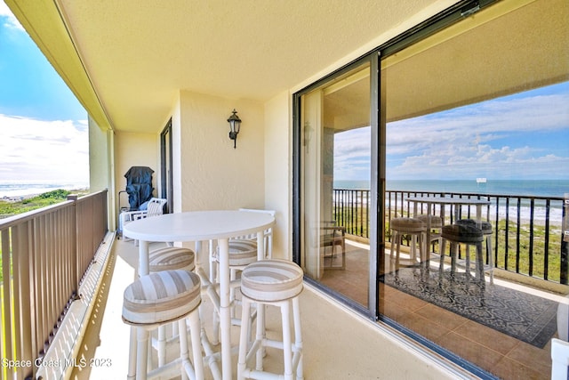 balcony with a water view and a beach view