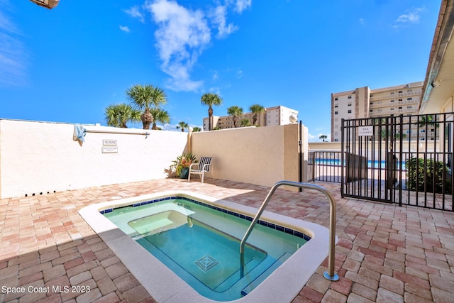 view of pool featuring a patio and a hot tub