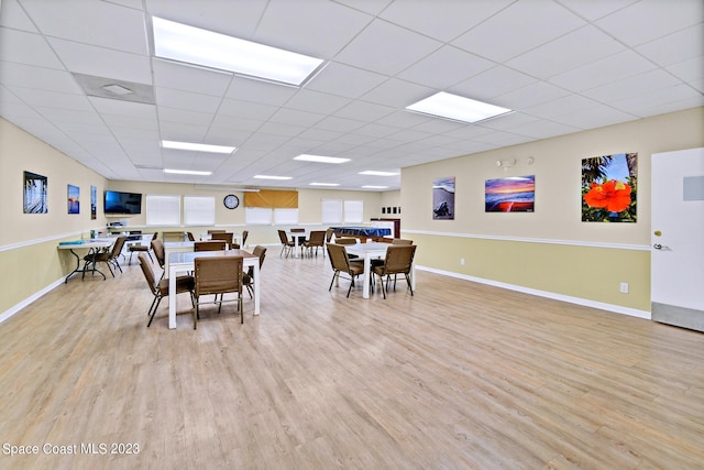 dining space featuring a paneled ceiling and light wood-type flooring