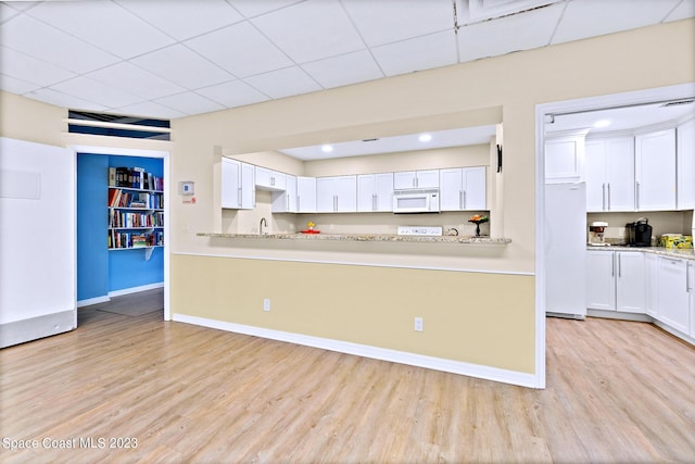 kitchen with refrigerator, light hardwood / wood-style floors, sink, and white cabinetry