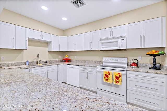 kitchen featuring light stone counters, white appliances, white cabinetry, and sink