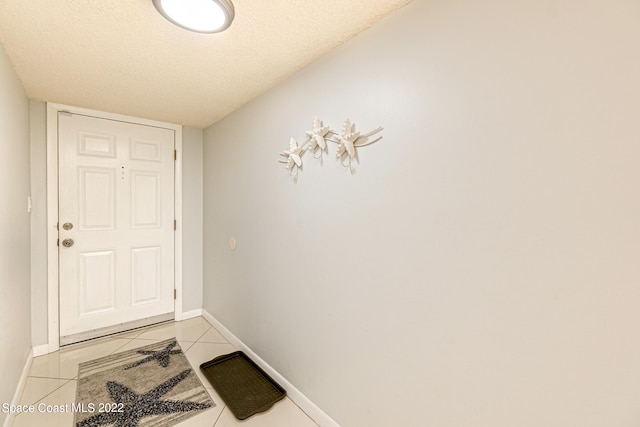 doorway to outside with light tile floors and a textured ceiling