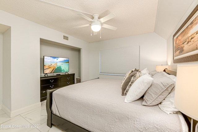 tiled bedroom with a textured ceiling and ceiling fan