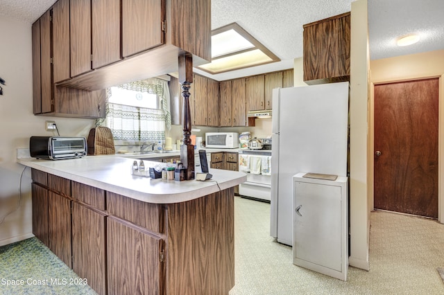 kitchen with white appliances, light carpet, a textured ceiling, and sink