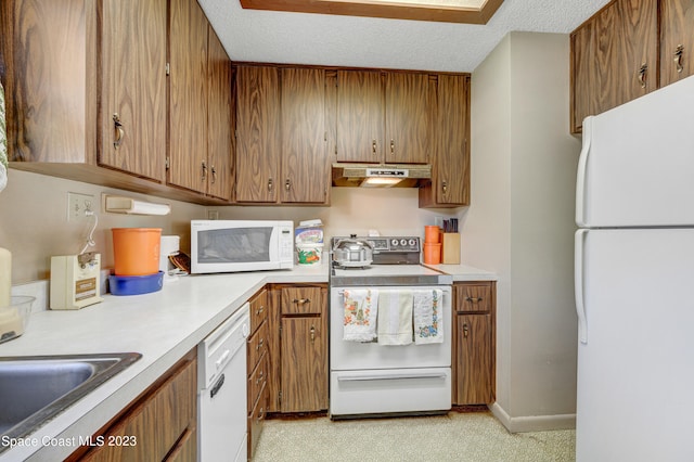 kitchen featuring white appliances, light carpet, and a textured ceiling