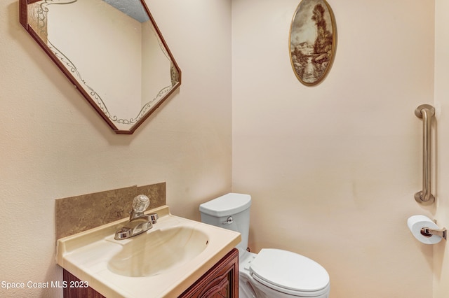 bathroom with large vanity and toilet