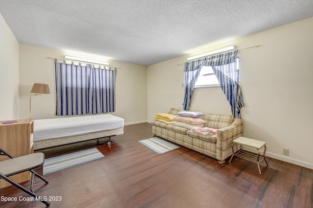 bedroom featuring a textured ceiling and dark hardwood / wood-style floors