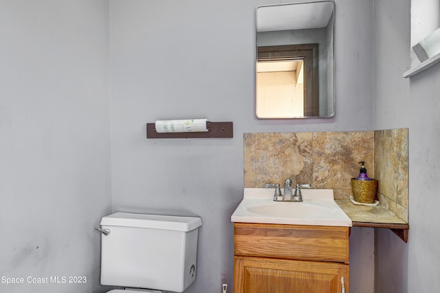 bathroom with toilet, tasteful backsplash, and large vanity